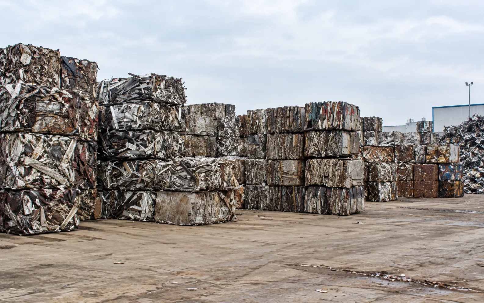Stacked bales of compressed scrap metal in a yard
